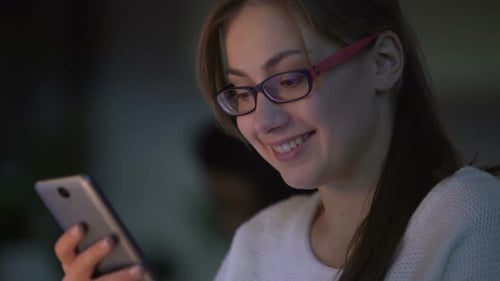 Young Woman Using Tablet Device at Night