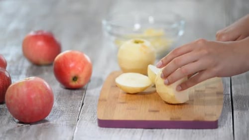 Apfel auf einem Schneidebrett in Stücke schneiden