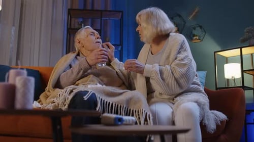 Loving Senior Woman Cares for Sick Senior Man