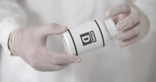 Gloved Hand Pours Out Vitamin D Pills