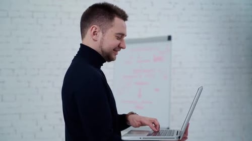 Young Adult Man Working on Laptop in Office