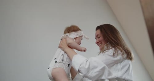 Mother Holding Baby and Kissing Her