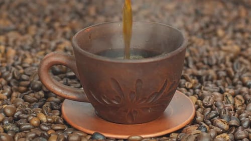 Coffee Pouring into Rustic Cup Surrounded by Beans