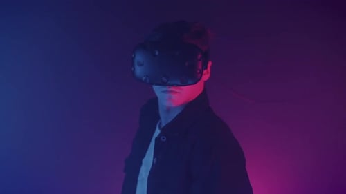 Person wearing VR headset in blue and red lighting