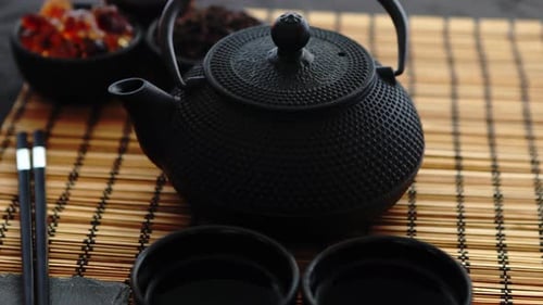 Juego de té verde asiático sobre tapete de bambú