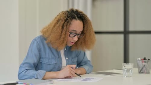 Woman Analyzing Charts and Graphs at Desk