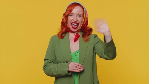 Redheaded Woman Smiling Friendly at Camera and Waving Hands Gesturing Hello or Goodbye Welcoming