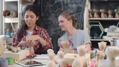 Two Women Crafting Animal Sculptures in Arts Studio