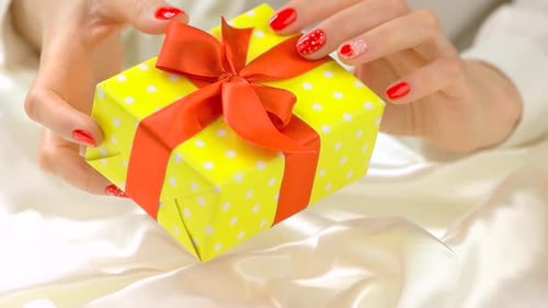 Woman Shows Beautiful Yellow Gift With Orange Bow