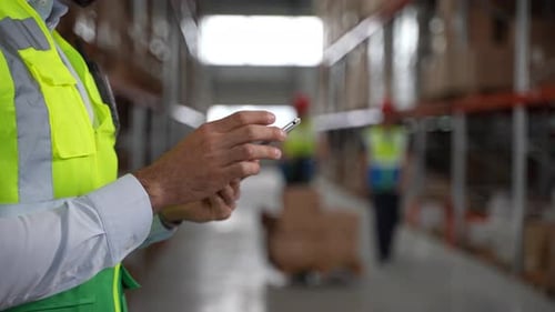 Tablette entre les mains d'un employé d'entrepôt pendant le travail