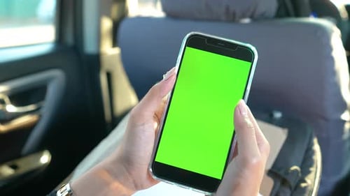 Woman Holding Phone inside a Car Taps Green Screen Phone Static