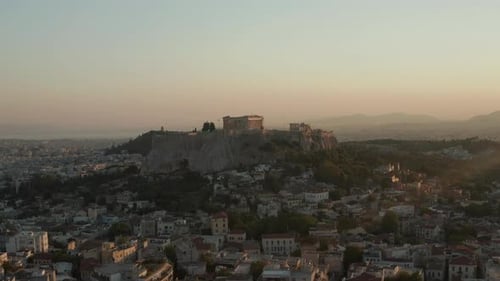 Slow Aerial Dolly Towards Mountain with Acropolis of Athens in Greece in Beautiful Golden Hour