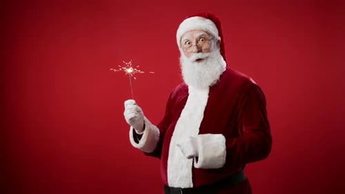 Santa Claus Holds a Sparkler on Red Background
