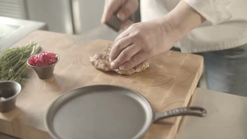 Chef Slicing Cooked Steak on Cutting Board
