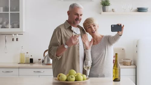 Couple Taking Selfie with Wine in Bright Kitchen