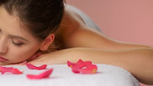 Woman Relaxing on Massage Table with Rose Petals