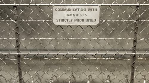 View at the fence with prison building. Barbed wires. Cameras. Danger zone 4k HD