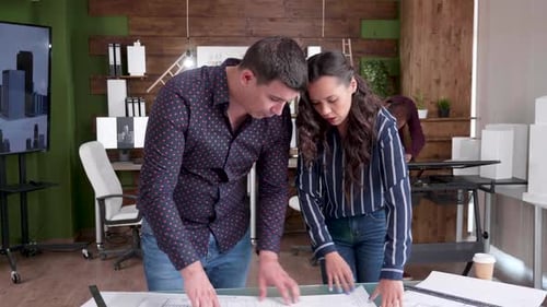 Architects Discussing Building Plans in Modern Office