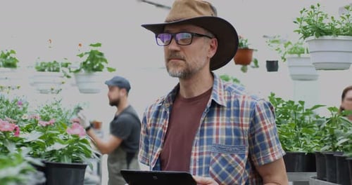 Man With Tablet in Greenhouse