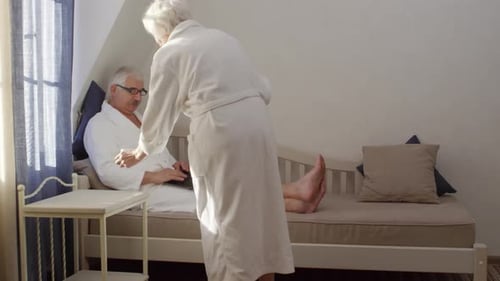 Elderly Lady Bringing Coffee for her Husband to Hotel Room