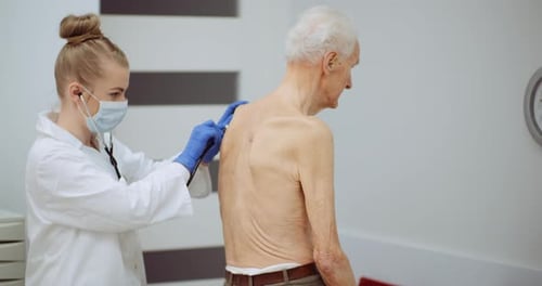 Doctor Examines Senior Patient with Stethoscope in Clinic