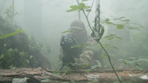 Camouflaged Soldier Armed in Misty Forest