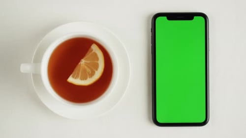 Black Tea and Smartphone with Green Chroma Key Screen Top View