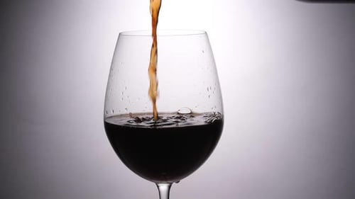 Pouring Dark Liquid into a Classy Wine Glass