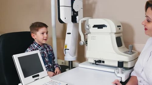 Doctor Examining Child Patient with Eye Exam Equipment