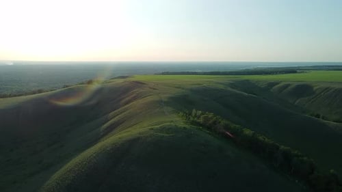 Aerial View of Green Hills in Sun Rays. Flying Above the Scenic Hills By Drone