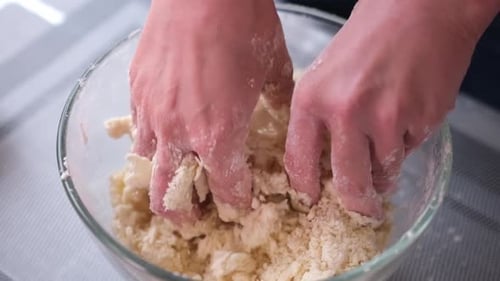 Hands Kneading Dough in Bowl Close Up