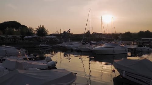 Boats in small marina on Lake Garda at sunset, sundown peaceful slow motion view
