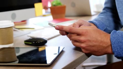 Businessman using mobile phone at desk