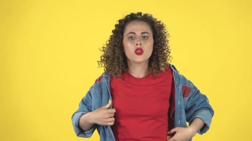 Jeune femme se rafraîchissant par la main, souffrant de températures élevées contre le jaune