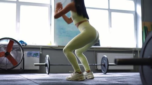 Vista lateral Deportista en forma motivada en cuclillas en el gimnasio
