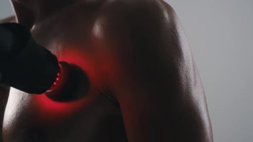 Man Uses Massage Gun for Muscle Soreness Relief
