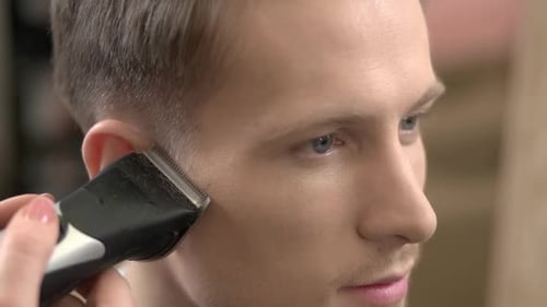Man Gets Haircut from Professional