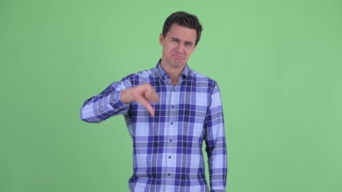 Young Man Thumbs Down in Front of Green Screen
