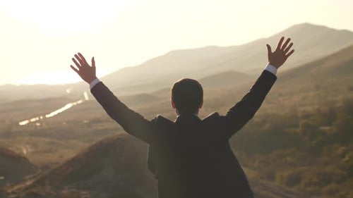 Man Celebrates Success on Hilltop at Sunrise