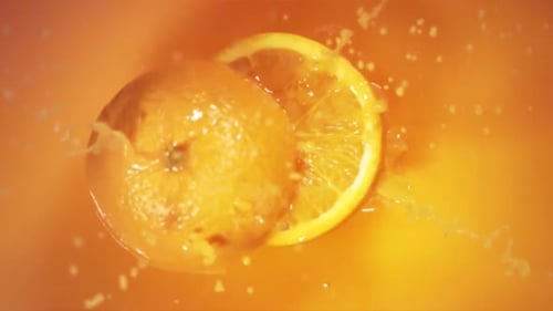 Orange Splashing Into Juice With a Slice