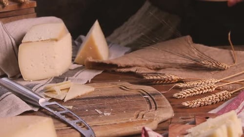 Women hands put wheels of fresh homemade cheese on a wooden board close up