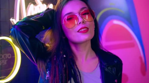 Stylish Woman Poses in Front of Neon Lights