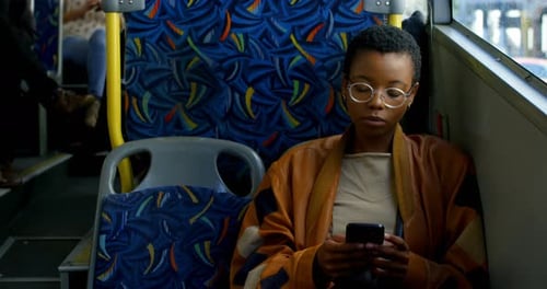 Woman Using Phone on City Bus