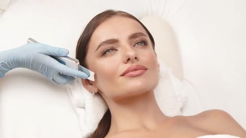Beautiful Woman at Spa Having Facial Treatment with Machine