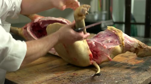 Butcher Cutting Pork Meat at Butchery Shop