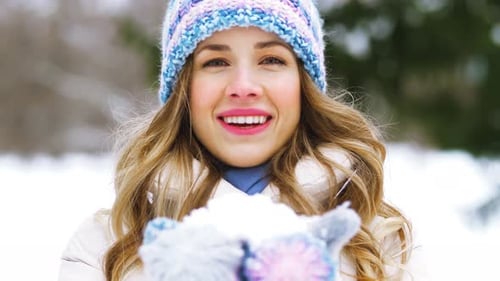 Happy Young Woman Blowing To Snow in Winter Forest 21