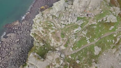 Top down aerial tracking backwards across the top of the rocky crag at the Valley of Rocks. Charity
