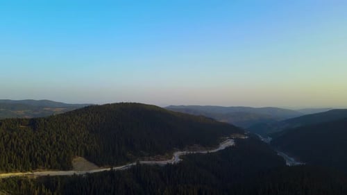 Steep green mountains, deep forest and mountain road, beautiful valley
