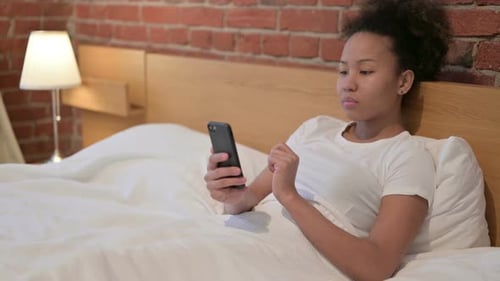 Woman Using Smartphone While Lying in Bed