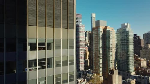 Slide and Pan Footage of High Rise Apartment Buildings in Midtown Illuminated By Bright Sun